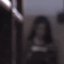 a girl in a suit and tie is reading a book in a dark room