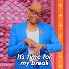 a man in a blue suit and glasses is looking at his watch and saying it 's time for my break .