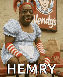 a person dressed as wendy 's henry sits on a bench in front of a wendy 's sign