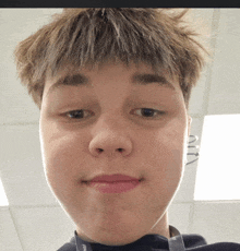 a young man with a lanyard around his neck that says ' ain ' on it looks at the camera