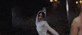 a woman in a white dress with a hood on her head