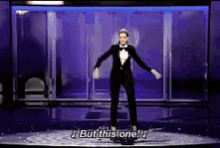 a man in a tuxedo and bow tie is dancing on a stage and says but this one