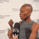 a woman is talking into a microphone at a national board of review event
