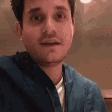 a close up of a man wearing a blue jacket and a white shirt .