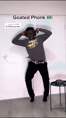 a man wearing headphones and a goated phonk shirt is dancing