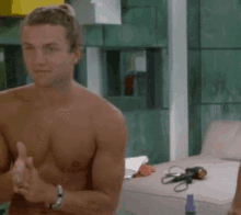 a shirtless man with a watch on his wrist stands in a room