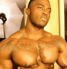 a muscular man with a tattoo on his chest that says tommy crow