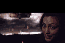 a close up of a woman 's face in a car at night