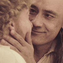 a man and a woman are touching their faces and smiling