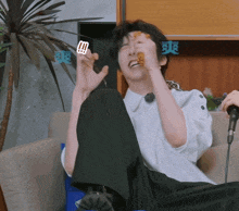 a man is sitting on a couch with his legs crossed and eating a piece of food