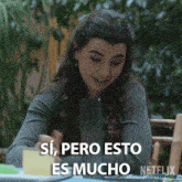 a woman is sitting at a table with a netflix logo in the background