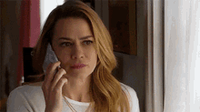 a woman is talking on a cell phone in a room .