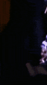a blurred image of a person 's face with a purple and orange background