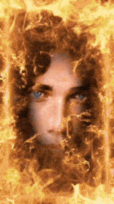 a man 's face is surrounded by flames and smoke