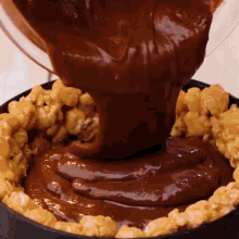 a chocolate sauce is being poured into a pie