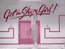 a woman stands on a yoga mat in front of a sign that says get in this girl