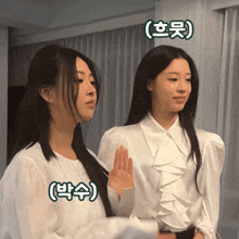 two women standing next to each other with chinese characters on their shirts