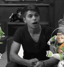 a young man sitting next to a toy story character buzz lightyear