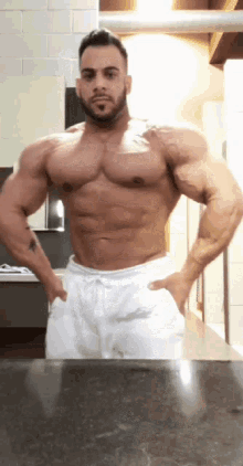 a shirtless man standing in front of a mirror with his hands on his hips