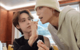 a man in a white hat is looking at another man