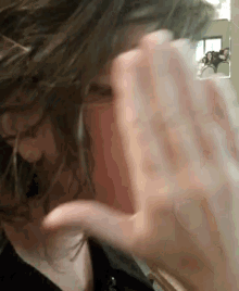 a close up of a woman 's face with her hand on her face