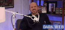 a man is sitting in front of a microphone with the words dark web on the bottom
