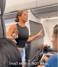 a woman is giving the middle finger on an airplane while a man looks on .