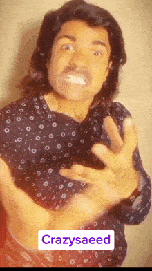 a man with long hair and a mustache is wearing a black shirt with white dots and the name crazysaeed on the bottom