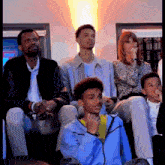 a group of people are sitting in a room with one wearing a nike jacket