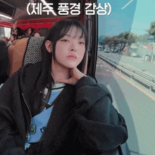 a girl sitting on a bus with chinese writing on the bottom