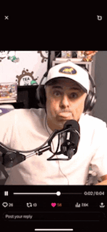 a man wearing headphones and a hat is talking into a microphone on a cell phone .
