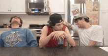 a man wearing a blue harley davidson sweatshirt sits at a table with two other men