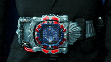 a person in a suit is wearing a belt that looks like a watch with a spider web on it