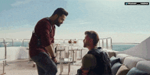 a man kneeling down next to another man with the words pranay varma on the bottom right