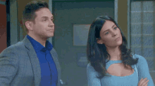 a man and a woman are standing next to each other in front of a door