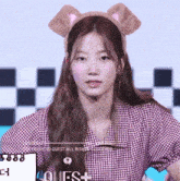 a girl wearing a headband with ears and the word quest on the bottom