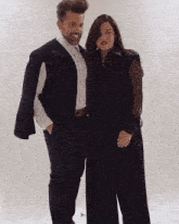 a man and a woman are posing for a picture and the man is wearing a black vest