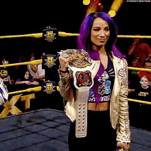 a woman with purple hair is holding a wrestling championship belt in a ring