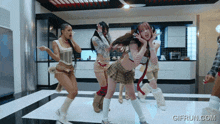 a group of women are dancing in a kitchen with the website gifrun.com visible in the corner