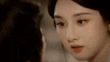 a close up of a woman 's face looking at another woman .