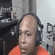 a man wearing headphones is sitting in front of a free cdn sign