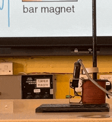 a bar magnet is displayed in front of a monitor