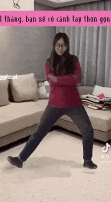 a woman is standing on one leg in front of a couch in a living room .