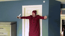 a man in a plaid shirt and hat is holding a knife