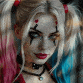 a close up of a woman 's face with harley quinn makeup on