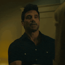 a man in a black shirt with buttons on the front