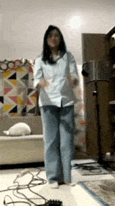 a woman in a blue shirt and blue pants is dancing
