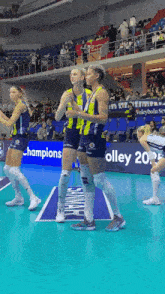 a group of female volleyball players stand on a court with a banner that says ' champions ' on it