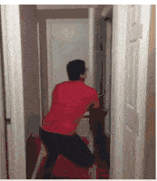 a man in a red shirt is pushing a door open