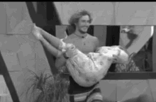 a man is carrying a woman in his arms .